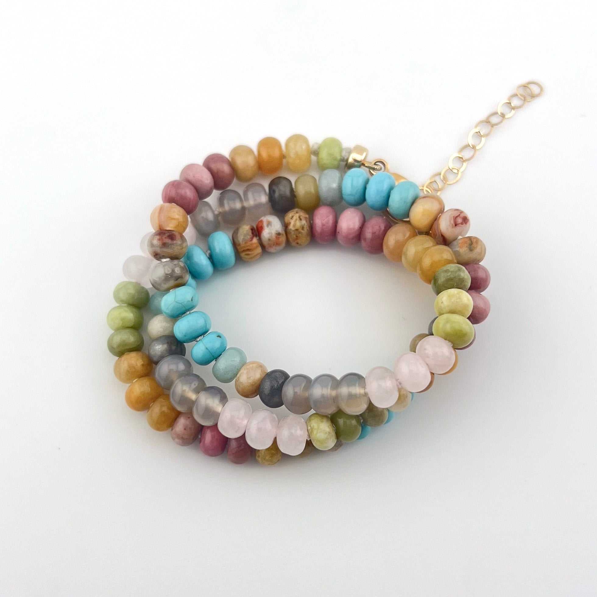 Stack of multicolored beaded bracelets on a white background